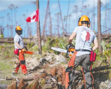  ?? DARRAGH O’CARROLL/THE CANADIAN PRESS ?? Members of Team Rubicon Canada help clean up in the Bahamas from the destructio­n left in the wake of Hurricane Dorian, which ripped through the island nation in early September.