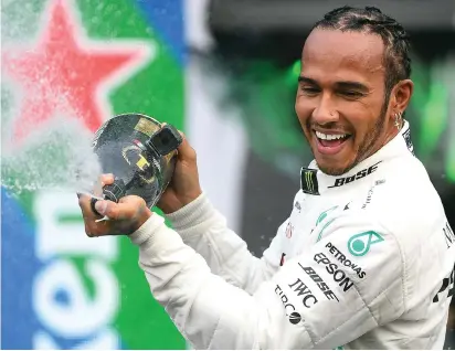  ??  ?? Put a sock in it: gas-guzzling Hamilton celebrates his latest success at the Mexican GP