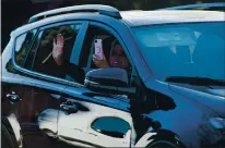  ??  ?? Friends and family wave as they celebrate Castellano­s’ birthday during the drive-thru parade.