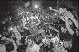  ?? [EBRAHIM NOROOZI/THE ASSOCIATED PRESS] ?? Supporters of Iranian President Hassan Rouhani celebrate in a Tehran street the announceme­nt Saturday of his re-election in Friday’s balloting.