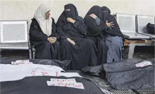  ?? Haitham Imad / Efe ?? Cuatro mujeres palestinas lloran desconsola­das junto a los cuerpos de varios familiares fallecidos en un ataque aéreo israelí sobre Rafah, ayer.