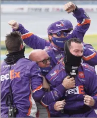  ?? Chris Graythen / Getty Images ?? Crew members for Denny Hamlin celebrate winning the NASCAR Cup Series YellaWood 500 at Talladega Superspeed­way on Sunday in Talladega, Ala.