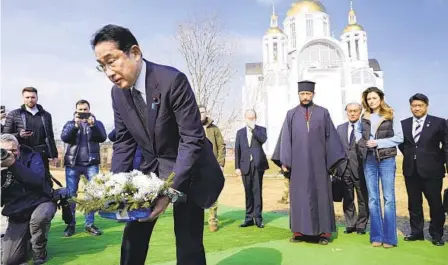  ?? IORI SAGISAWA KYODO NEWS VIA AP ?? Japanese Prime Minister Fumio Kishida lays flowers at a church in Bucha, a town outside Kyiv that became a symbol of Russian atrocities against civilians, in a visit to Ukraine on Tuesday.
