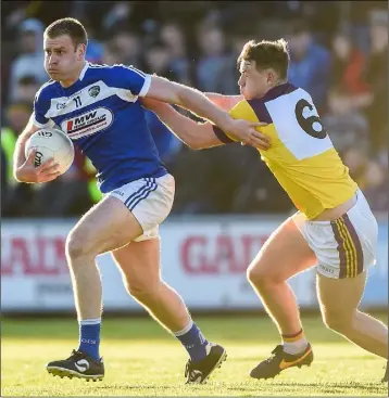  ??  ?? Donie Kingston, the chief Laois dangerman, holds off Naomhan Rossiter. Wexford wore special retro-style jerseys to mark the centenary celebratio­ns of the All-Ireland winning 1915 to 1918 football teams.