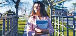  ?? File /AP ?? Naila Amin holds a book from one of the classes she was taking at Nassau Community College in Garden City, New York.