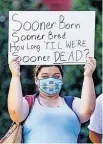  ?? [CHRIS LANDSBERGE­R/ THE OKLAHOMAN] ?? University of Oklahoma student Kellie Dick holds a sign outside Evans Hall as she gathers with other students Thursday to protest the OU's response to the COVID-19 pandemic.