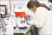  ?? Associated Press ?? A researcher at Protein Sciences works in a lab, Thursday in Meriden. The biotech company is currently researchin­g a vaccine for COVID-19.