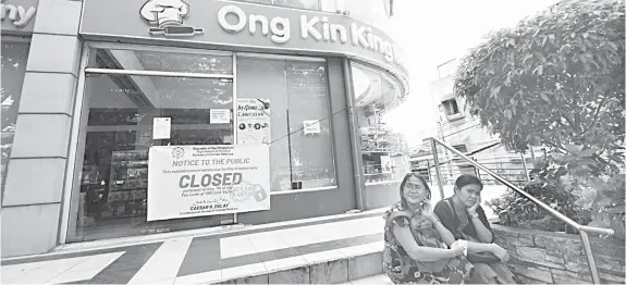  ?? PAUL JUN E. ROSAROSO ?? The Bureau of Internal Revenue shuts down Ong Kin King stores in Cebu City for alleged non-payment of taxes.