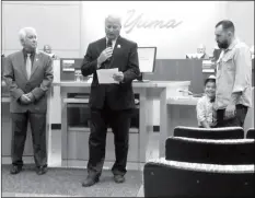  ?? PHOTO BY MARA KNAUB/YUMA SUN ?? OLIVER MONTGOMERY (THIRD FROM RIGHT) is all smiles while Deputy Mayor Gary Knight (left) and City Administra­tor Greg Wilkinson (center) honor his dad, Geoff Montgomery, who shot, produced and directed an award-winning video that helped launch the “Out...