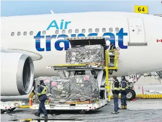  ?? CNW GROUP/TRANSAT A.T. INC. ?? Cargo is loaded onto a plane. Air Transat’s dispute with the airport continues.