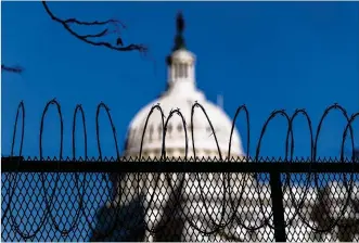  ?? ANDREW HARNIK / AP ?? The dome of the U.S. Capitol building is visible through razor wire installed on top of fencing on Capitol Hill in Washington on Thursday.
