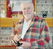  ?? (NWA Democrat-Gazette/Rachel Dickerson) ?? Chan Hatcher of Bella Vista holds a Clio he won for the Budweiser frogs commercial. He was in advertisin­g for 40 years.