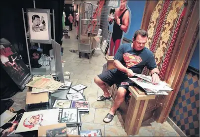  ?? JIM WEBER/THE COMMERCIAL APPEAL ?? Profession­al wrestling legend Jerry “The King” Lawler sorts through photos and memorabili­a from his 43-year career Wednesday afternoon while installing exhibits for the Jerry Lawler Museum at the Resorts Casino in Tunica. The museum opens Saturday.