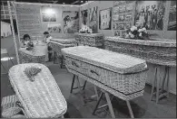  ?? AP/VINCENT YU ?? Wicker and seagrass coffins are displayed at the Asia Funeral and Cemetery Expo & Conference last week in Hong Kong.