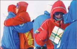  ??  ?? Members of the team embrace each other after they reach the North Pole.