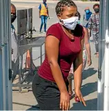  ?? AP ?? A woman wearing face masks to protect against coronaviru­s, walks through a disinfecti­ng spray booths aimed to combat the spread of Covid-19 at Alexandra township in Johannesbu­rg, South Africa.