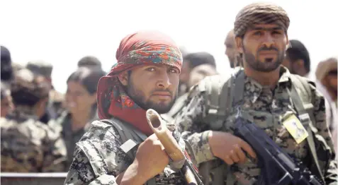  ??  ?? Members of the US-backed Syrian Democratic Forces stand in the village of Hazima on the northern outskirts of Daesh's Syrian bastion of Raqqa on Tuesday. (AFP)