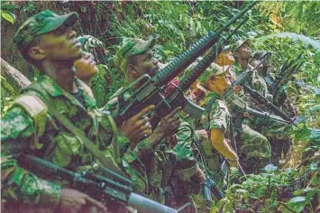  ?? FEDERICO RIOS/THE NEW YORK TIMES 2016 ?? A court in Colombia is exposing atrocities in the South American country’s long civil war. Above, a group of FARC rebels in the jungle months before the Colombian government struck a peace deal with the group.