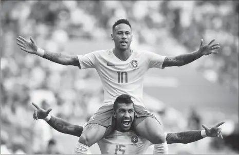  ??  ?? Brazil forward Neymar (No.10) celebrates with teammate Paulinho after scoring the opening goal during their World Cup round-of-16 match against Mexico on Monday at the Samara Arena in Samara, Russia.