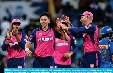  ?? ?? MUMBAI: Rajasthan Royals’ Trent Boult (C) celebrates with teammates after taking the wicket of Mumbai Indians’ Naman Dhir during the Indian Premier League (IPL) Twenty20 cricket match between Mumbai Indians and Rajasthan Royals at the Wankhede Stadium in Mumbai on April 1, 2024. — AFP