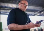  ?? RAY CHAVEZ — BAY AREA NEWS GROUP, FILE ?? Farhan Zaidi, president of baseball operations for the Giants, checks this cellphone after speaking to members of the media during spring training at Scottsdale Stadium in Scottsdale, Ariz., on Jan. 18.