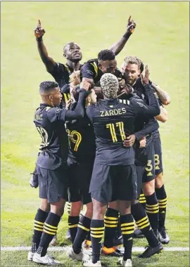  ?? Jay LaPrete Associated Press ?? COLUMBUS CREW players celebrate a goal against the visiting Seattle Sounders en route to their 3- 0 win in the MLS championsh­ip match Saturday.