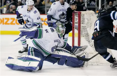  ?? TREVOR HAGAN/THE CANADIAN PRESS ?? Vancouver Canucks goaltender Jacob Markstrom stops Winnipeg Jets left winger Nic Petan during the second period on Tuesday in Winnipeg.