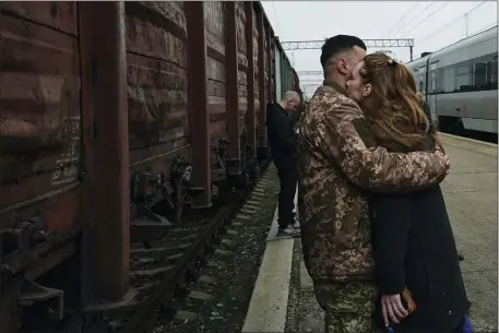  ?? LIBKOS — THE ASSOCIATED PRESS ?? A Ukrainian soldier says goodbye to his wife as she takes a train at a railway station in Kramatorsk, Donetsk region, Ukraine, Tuesday. It’s a scene played out countless times now.