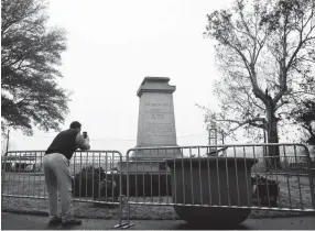  ??  ?? Memphian Brett Schutt takes a picture of the removed statue of Confederat­e President Jefferson Davis in Fourth Bluff Park Thursday morning. The city of Memphis sold two public parks containing Confederat­e monuments to a nonprofit Wednesday in a...