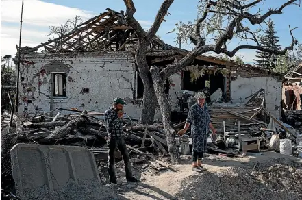  ?? GETTY IMAGES ?? Ukrainian couple Larysa, 55, and Viktor, 57, look at the remains of their home in the village of Pidhaine, near the capital, Kyiv. As Russia concentrat­es its attack on the east and south of the country, residents of the Kyiv region are returning to assess the war’s toll on their communitie­s.