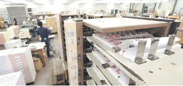  ??  ?? A machine finishing the last steps for printing at a factory of Japan’s major calender maker Todan in the town of Ami, Ibaraki prefecture. – AFP photo