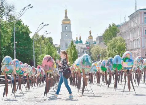  ?? EUROVISION VENUE: — AFP ?? A tourist walks in front of St Sophia Cathedral with decorated Easter eggs in Kiev on Friday. The Eurovision Song Contest 2017 will be held in the Ukrainian capital from May 9 to 13.