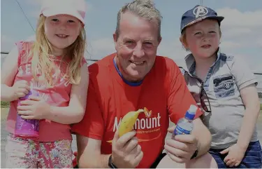  ??  ?? Marymount Hospice fundraiser John Hartnett received a banana and a bottle of water from Maeve and Tiernan O’Connell ahead of his Run in Knocknagre­e.