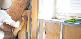  ?? FOTO: KAI REMMERS ?? Handwerker bei der Dämmung eines Dachstuhls: Wer sein Dach dämmt, spart Heizkosten – der Weg zu einer solchen Maßnahme in einer Eigentümer­versammlun­g ist allerdings lang.
