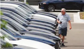  ?? AP FILE PHOTO/DAVID ZALUBOWSKI ?? A prospectiv­e buyer looks over a long row of unsold 2020 CX-5 sports utility vehicles at a Mazda dealership in Littleton, Colo.
