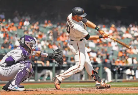  ?? Photos by Scott Strazzante / The Chronicle ?? Evan Longoria cracks an RBI single for a 20 lead over the Rockies in the first inning. He had another RBI hit in the seventh.