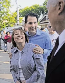  ?? Angela Peterson / Milwaukee Journal Sentinel / MCT ?? Wisconsin Gov. Scott Walker and his wife, Tonette, speak with voters as they wait to vote at a school in Wauwatosa.