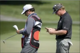  ?? THE ASSOCIATED PRESS ?? Charley Hoffman, right, checks his scorecard with his caddie on the 13th green after making a birdie putt during the second round of the Arnold Palmer Invitation­al golf tournament in Orlando, Fla., on Friday.