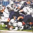  ?? Tim Bradbury / Getty Images ?? Cincinnati’s Michael Warren rushes for a touchdown in the second quarter against UConn on Saturday.