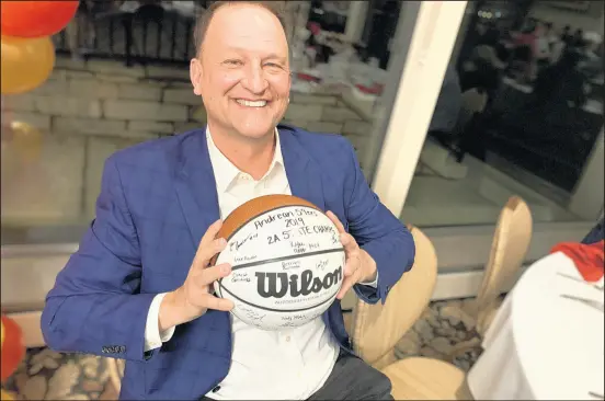  ?? MIKE HUTTON/POST-TRIBUNE ?? Dan Dakich holds a basketball signed by Andrean’s state championsh­ip team at Innsbrook Country Club on Monday.