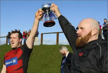  ??  ?? The Declan Finn Cup is risen aloft in triumph by captain Steve Roche and coach Rory Flynn.