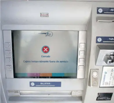  ?? ARIANA CUBILLOS / THE ASSOCIATED PRESS ?? An automated cash machine displays a temporary out of service message in Caracas on Monday after the Venezuela’s currency was devalued by 95 per cent and banks struggle to adapt to a new bolivar.