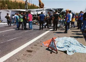  ?? Ihlas News Agency ?? Rescue teams gather at the site where a passenger bus crashed into emergency crews who were handling a previous road accident in southern Turkey. At least 15 people died in the collision.