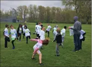  ??  ?? Second- and third-grade team member stretch and warm up before their half-mile run during Healthy Kids Running Series at Coulby Park in Wickliffe on April 25.