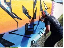  ?? ?? BELOW Buntu Fihla is hard at work on his colourful wall tag in Bisho, Eastern Cape.