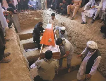  ?? Rafiq Maqbool Associated Press ?? THE BODY of a victim of the wedding hall bombing is carried to a grave in Kabul during a mass funeral.