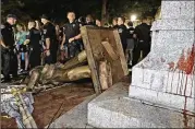  ?? GERRY BROOME / ASSOCIATED PRESS ?? Police stand guard after the Confederat­e statue “Silent Sam” was toppled Monday by protesters at the University of North Carolina in Chapel Hill.