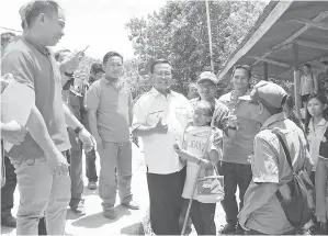  ??  ?? BOLKIAH mengabadik­an gambar kenangan bersama seorang ibu tua.