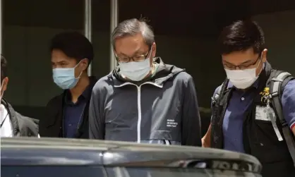  ?? Photograph: Kin Cheung/AP ?? Police officers escort Cheung Kim-hung (centre) at Apple Daily’s Hong Kong headquarte­rs in June.