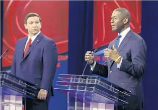  ?? CHRIS O’MEARA/AP ?? Florida Democratic gubernator­ial candidate Andrew Gillum, right, speaks as Republican gubernator­ial candidate Ron DeSantis looks on during a CNN debate in Tampa.